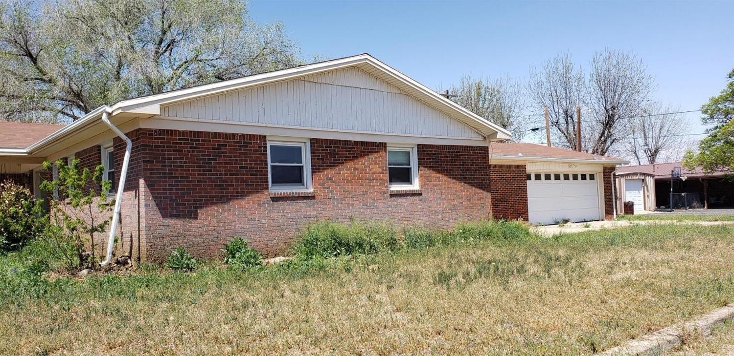 1007 2nd Street Plains, TX 79355 - Photo 2 of 11 a view of a house with a yard and potted plants