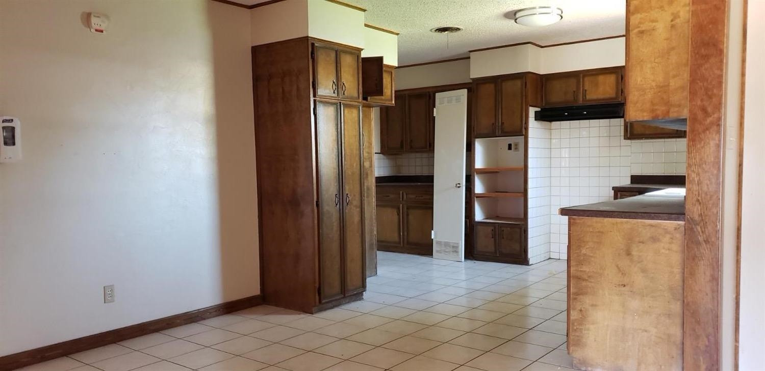 1007 2nd Street Plains, TX 79355 - Photo 7 of 11 a kitchen with stainless steel appliances a refrigerator and cabinets