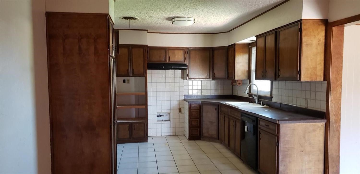 1007 2nd Street Plains, TX 79355 - Photo 8 of 11 a kitchen with stainless steel appliances granite countertop a refrigerator and a sink