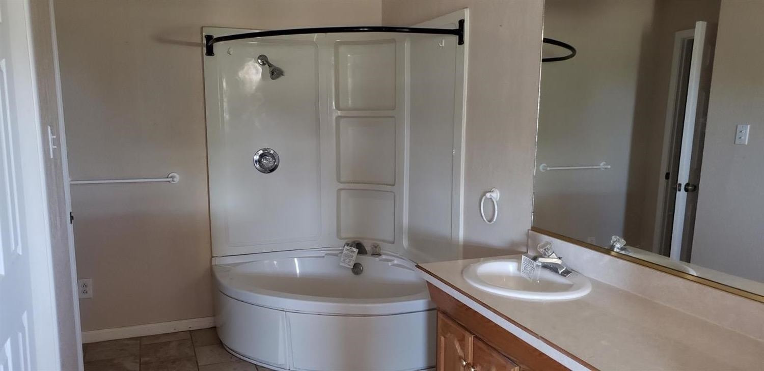 1007 2nd Street Plains, TX 79355 - Photo 10 of 11 a bathroom with a sink and a mirror