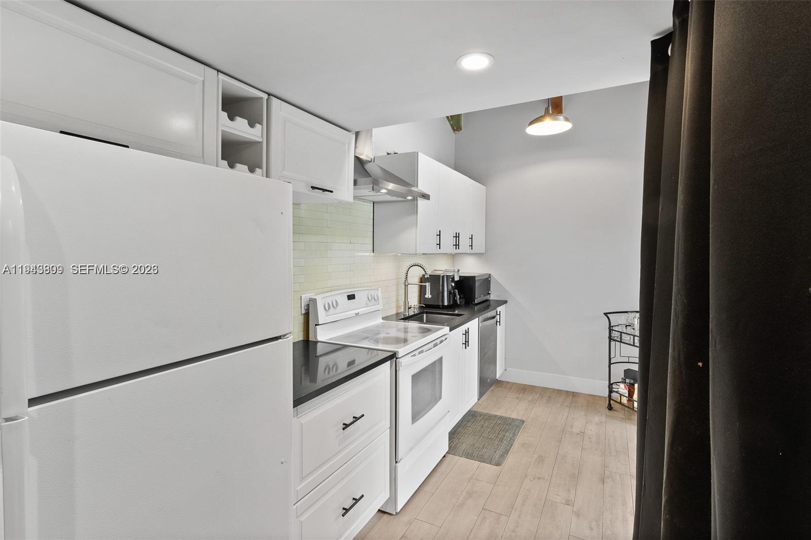 8331 Southwest 157th Avenue, Unit 409 Miami, FL 33193 - Photo 5 of 19 a kitchen with white cabinets and white appliances