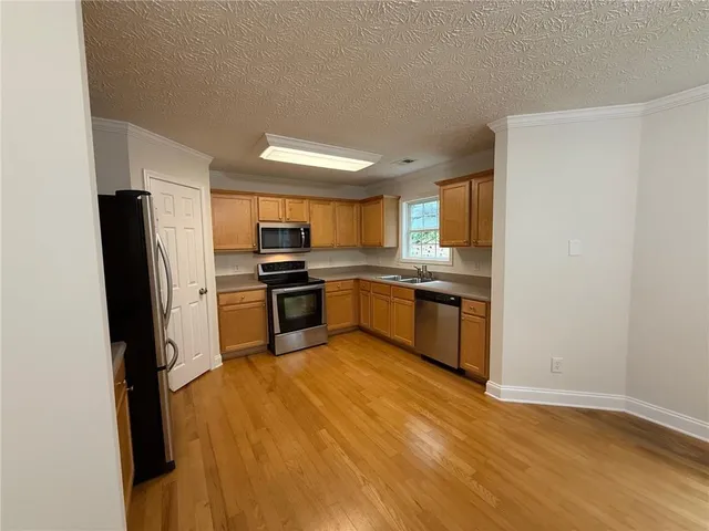 an empty room with chandelier fan and windows