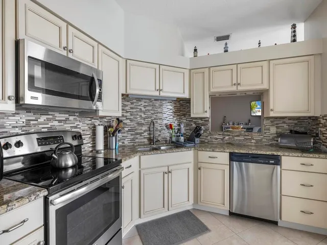 a kitchen with white cabinets and appliances