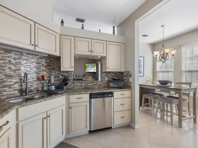 a kitchen with white cabinets and sink