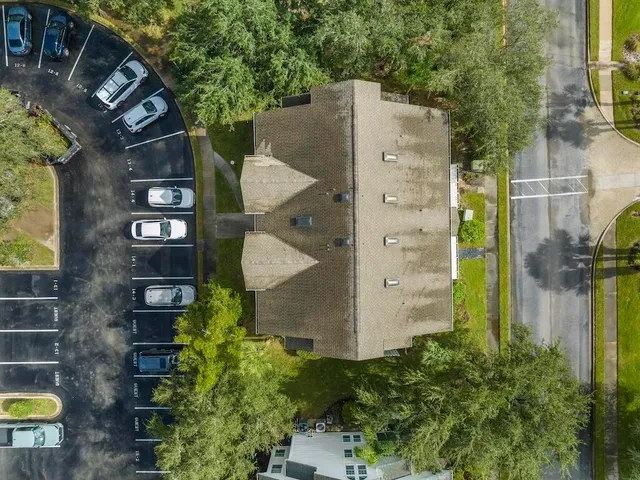an aerial view of a residential houses with yard