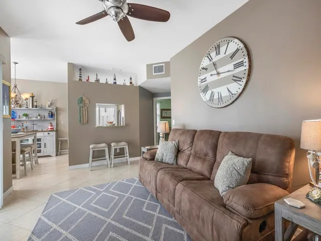 a living room with furniture a clock on wall and a table