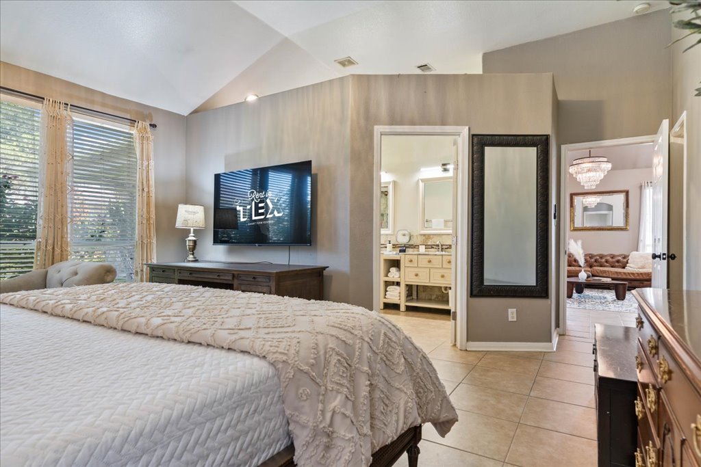 1505 Laurel Oak Loop Round Rock, TX 78665 - Photo 25 of 40 a bedroom with a large bed and a large mirror