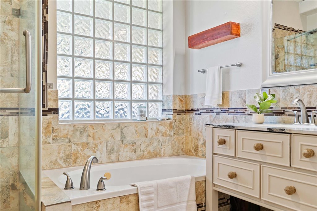 1505 Laurel Oak Loop Round Rock, TX 78665 - Photo 28 of 40 a bathroom with a granite countertop sink a mirror and a bathtub