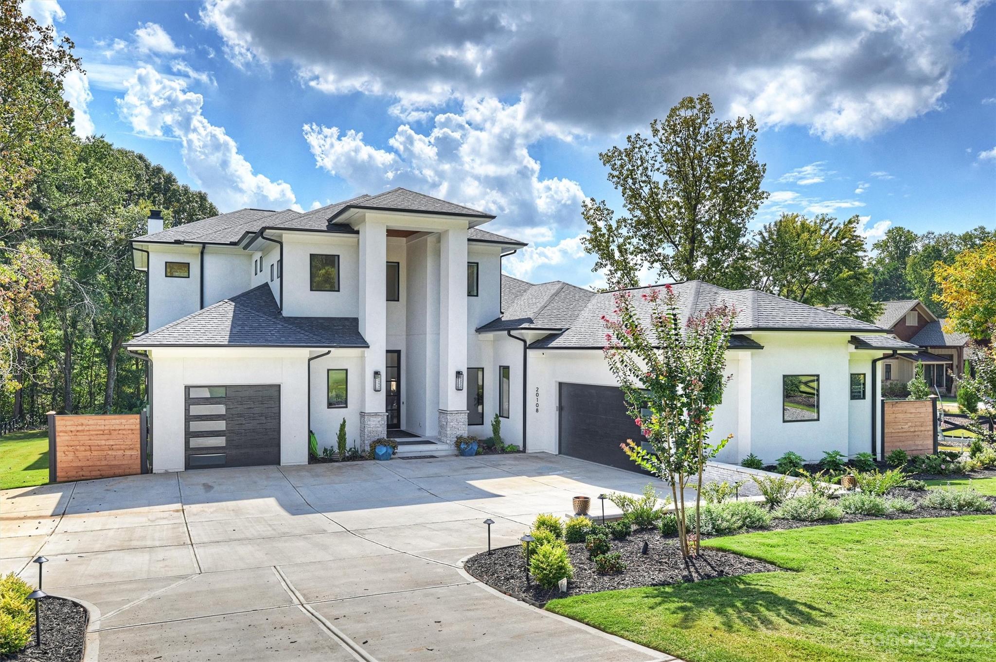 a front view of a house with a garden and a tree