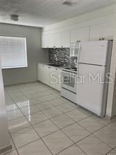 702 Michigan Court, Unit 4 St. Cloud, FL 34769 - Photo 4 of 9 a kitchen with white cabinets and white appliances