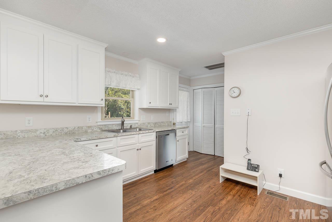 200 Ridge Road Northwest Wilson, NC 27896 - Photo 11 of 25 a kitchen with a sink cabinets stainless steel appliances and wooden floor