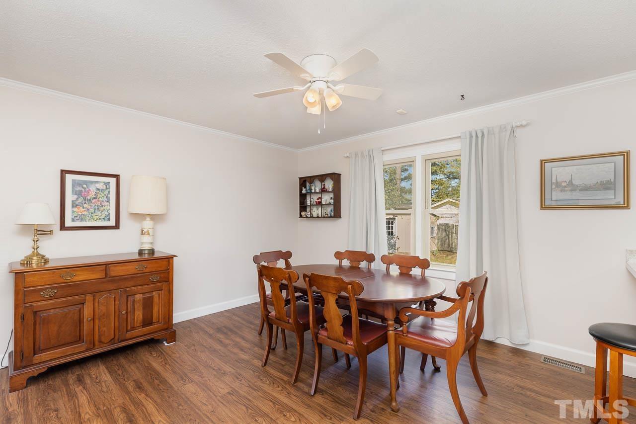 200 Ridge Road Northwest Wilson, NC 27896 - Photo 8 of 25 a dining room with wooden floor a chandelier fan a wooden table and chairs