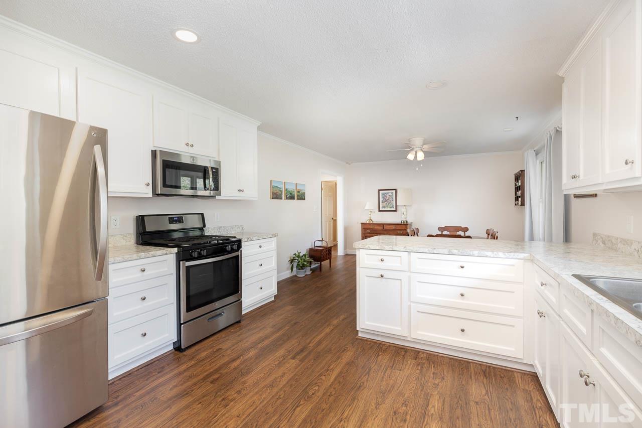 200 Ridge Road Northwest Wilson, NC 27896 - Photo 9 of 25 a kitchen with white cabinets stainless steel appliances and wooden floor