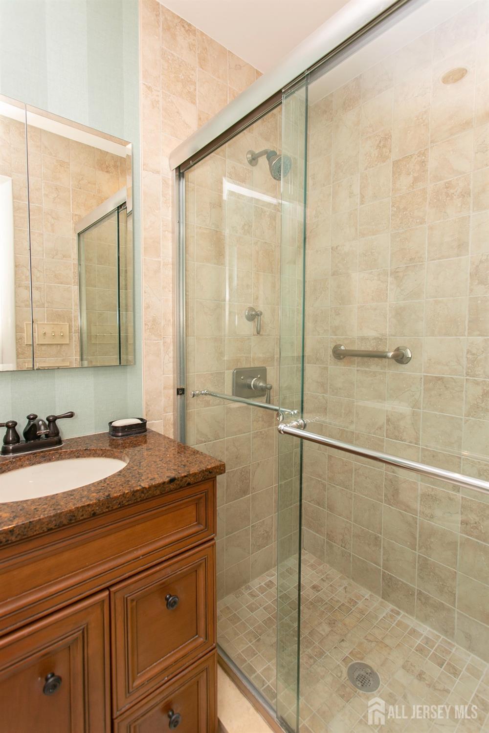 24 Huntington Road Edison, NJ 08820 - Photo 25 of 37 a bathroom with a granite countertop sink a mirror and shower