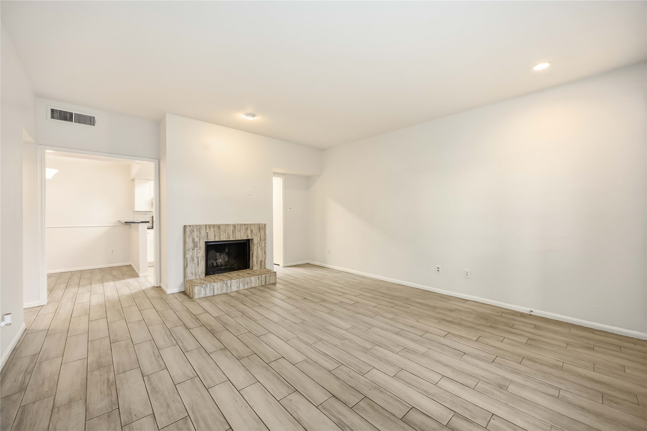 2100 Tanglewilde Street, Unit 531 Houston, TX 77063 - Photo 3 of 25 a view of an empty room with wooden floor fireplace and a window