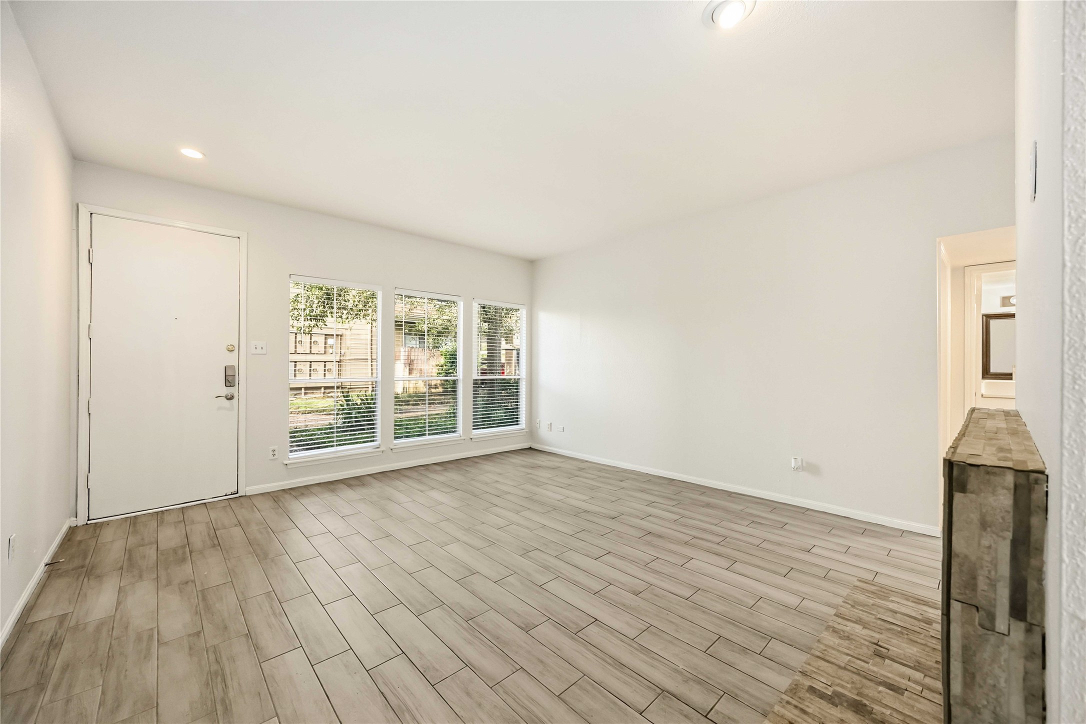 2100 Tanglewilde Street, Unit 531 Houston, TX 77063 - Photo 4 of 25 a view of an empty room with wooden floor and a window