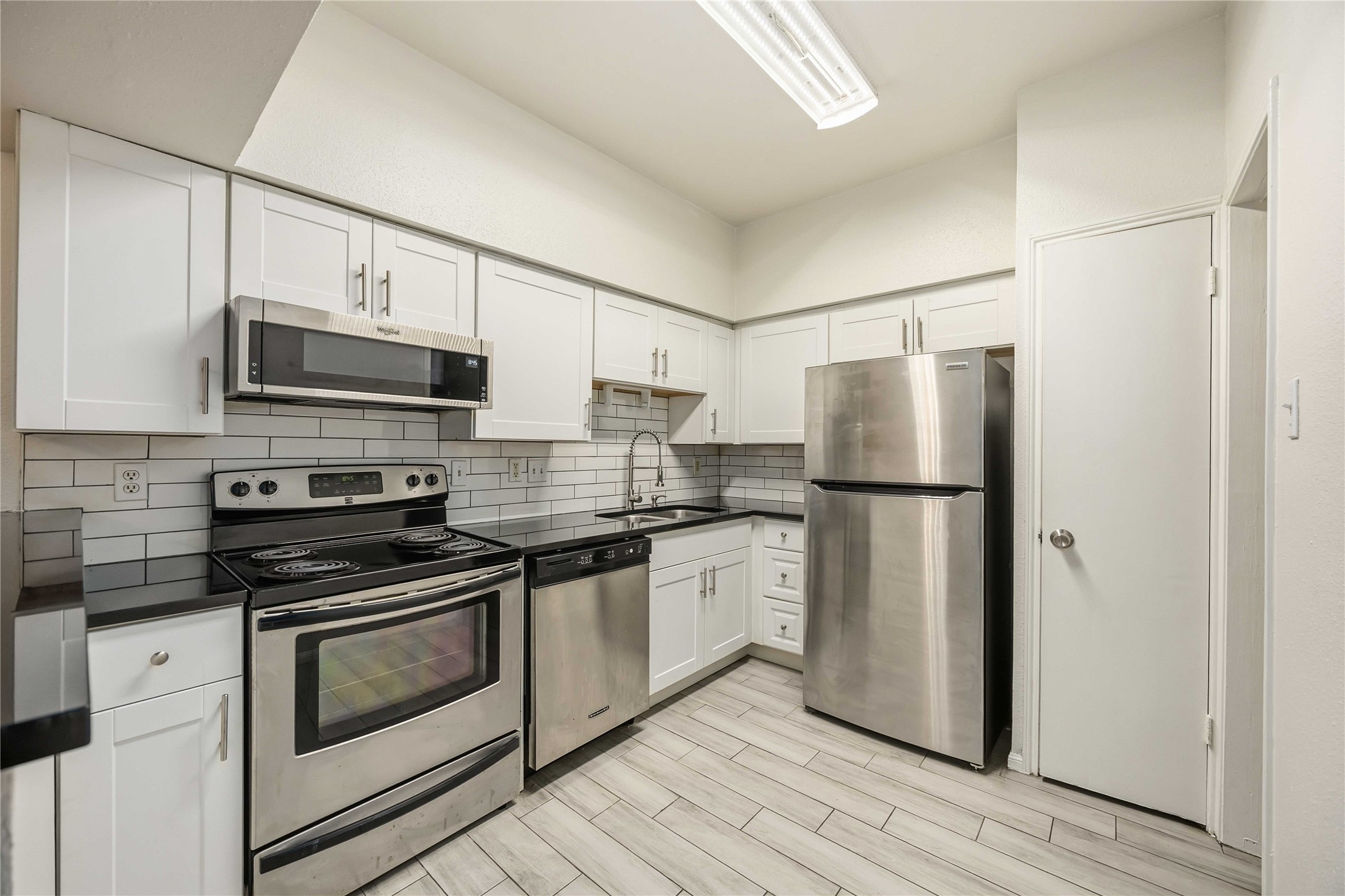2100 Tanglewilde Street, Unit 531 Houston, TX 77063 - Photo 6 of 25 a kitchen with stainless steel appliances a refrigerator stove and microwave