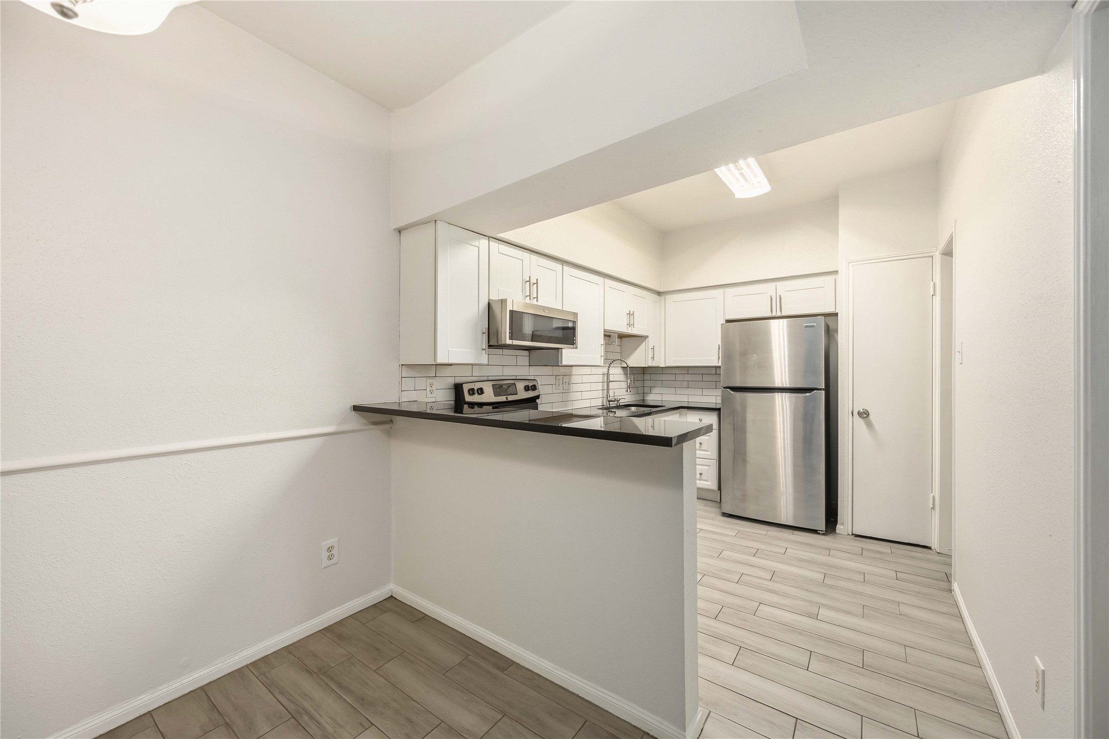 2100 Tanglewilde Street, Unit 531 Houston, TX 77063 - Photo 8 of 25 a kitchen with stainless steel appliances a refrigerator and a stove top oven