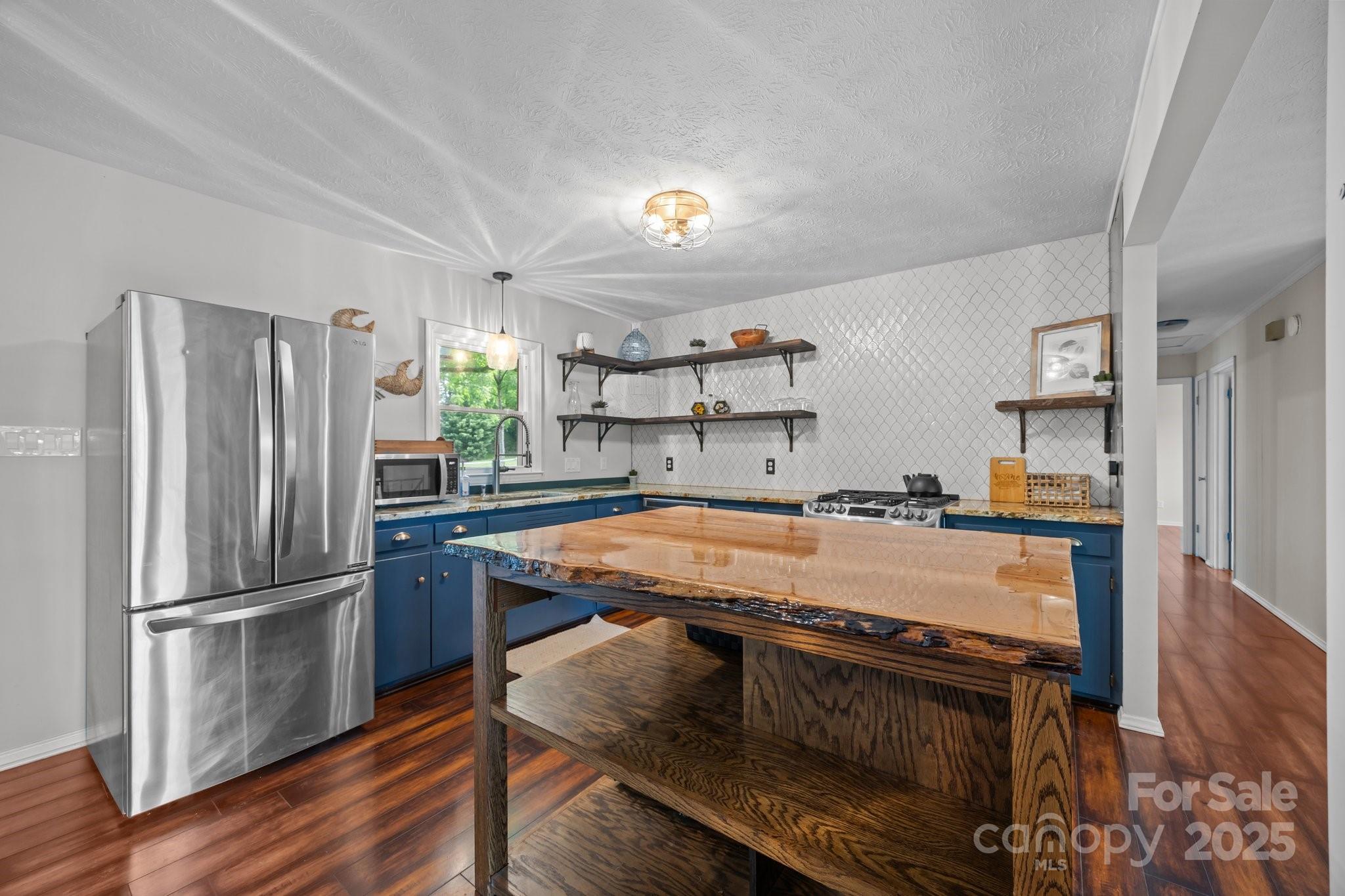 917 West Chapel Road Asheville, NC 28803 - Photo 13 of 28 a kitchen with granite countertop a refrigerator stove and wooden floor