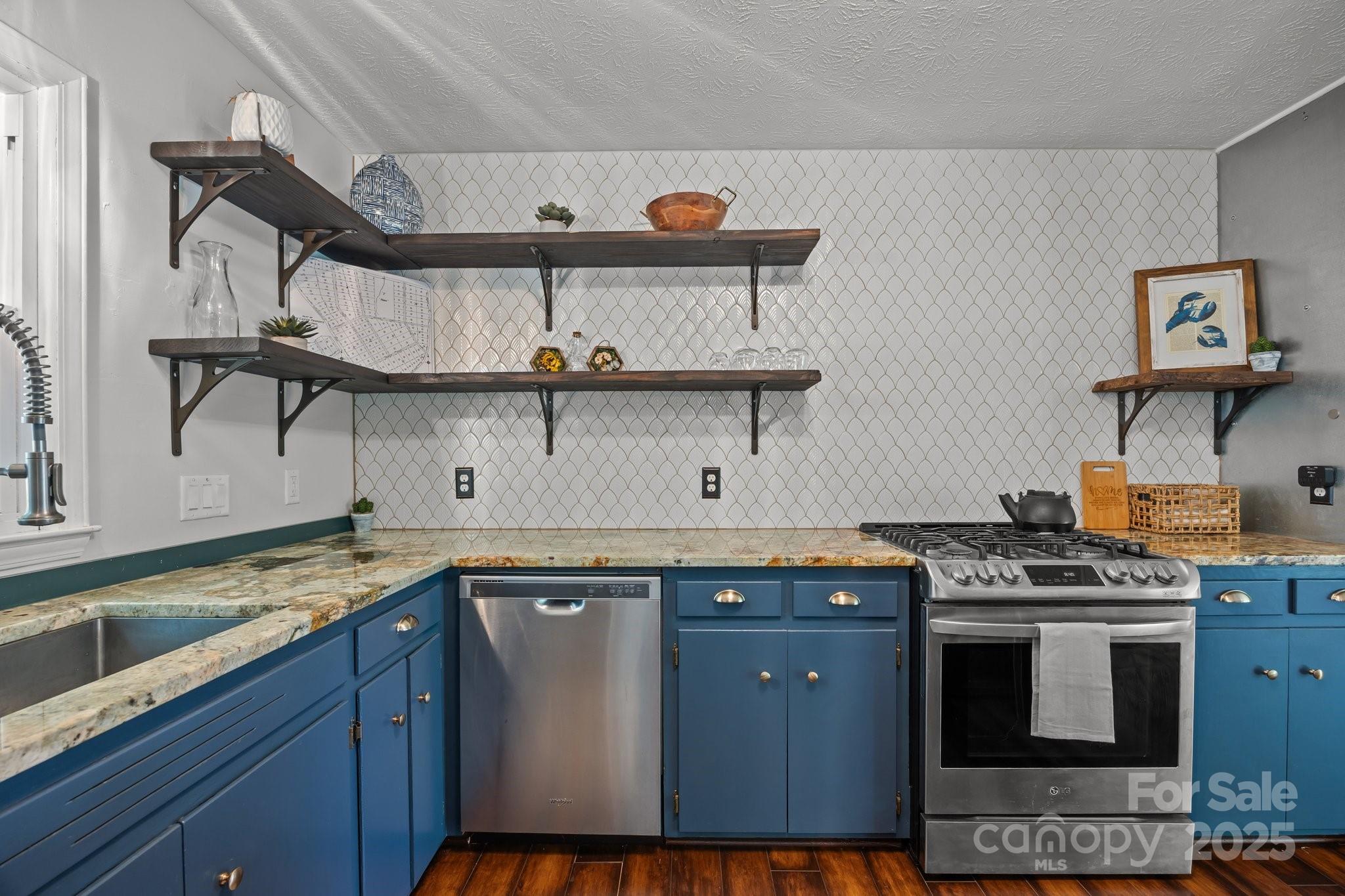 917 West Chapel Road Asheville, NC 28803 - Photo 2 of 28 a kitchen with stainless steel appliances granite countertop a stove a sink and a microwave