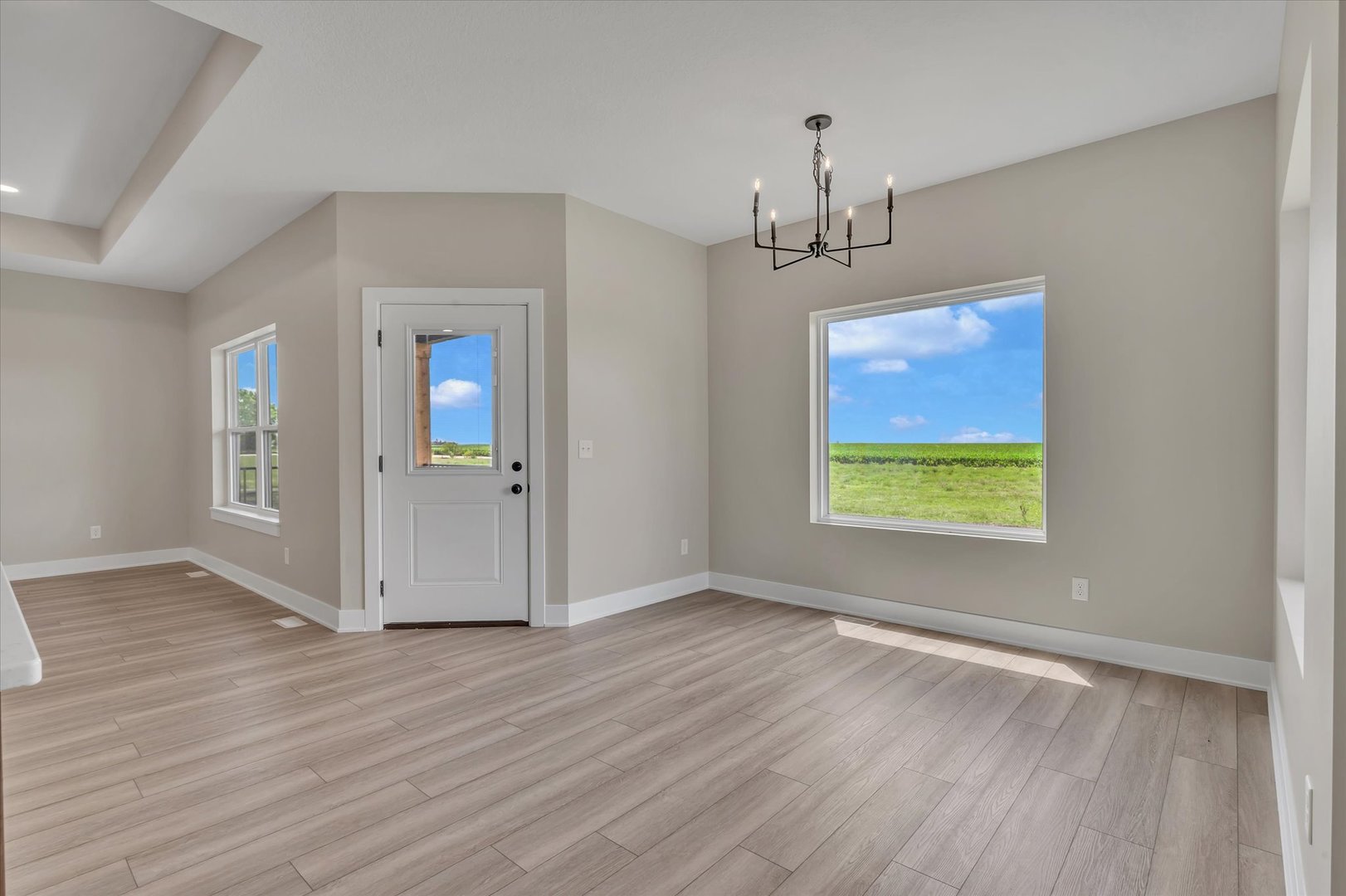 455 Rhonda Road New Liberty, IA 52765 - Photo 25 of 54 an empty room with wooden floor chandelier and windows