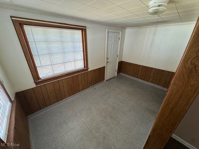 1507 Babbitt Road Euclid, OH 44132 - Photo 3 of 10 Empty room with wooden walls, a wainscoted wall, and tile patterned floors