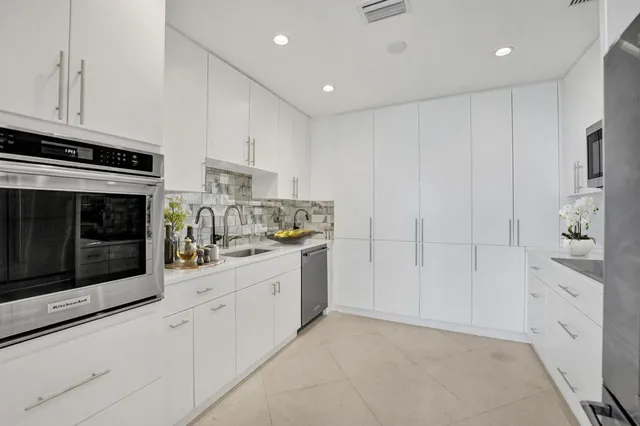 a kitchen with white cabinets and white appliances