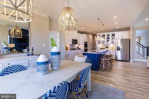 a dining room with wooden floor a chandelier a wooden table and chairs