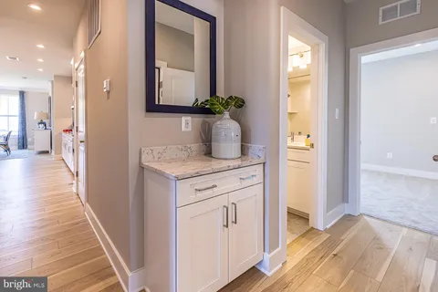 a hallway view with wooden floor and staircase