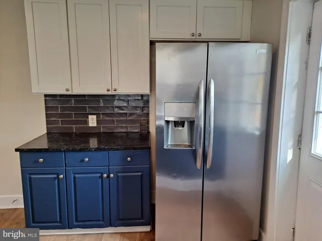 a kitchen with stainless steel appliances granite countertop a refrigerator a sink a stove a microwave a counter and a cabinets