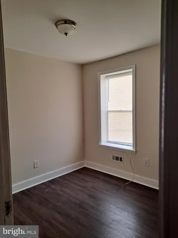 a view of a small space with wooden floor and a window