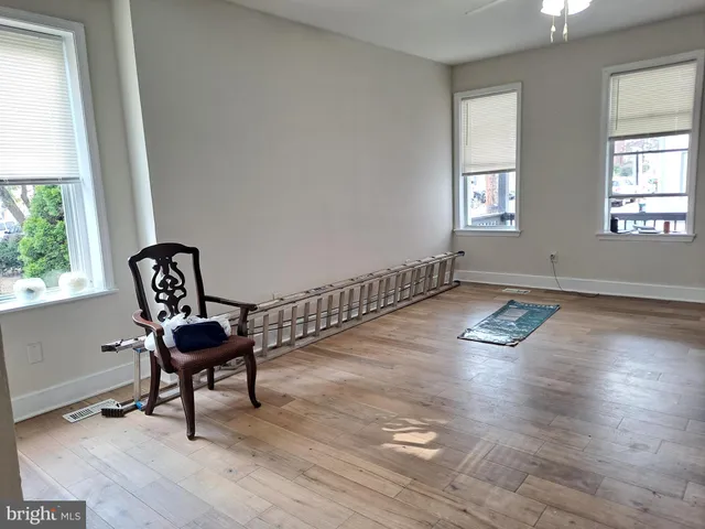 a view of a livingroom with wooden floor and a ceiling fan