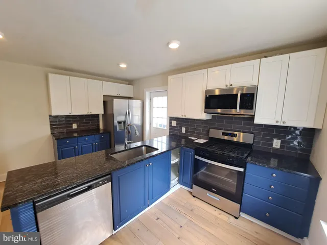 a kitchen with stainless steel appliances granite countertop a stove microwave and sink