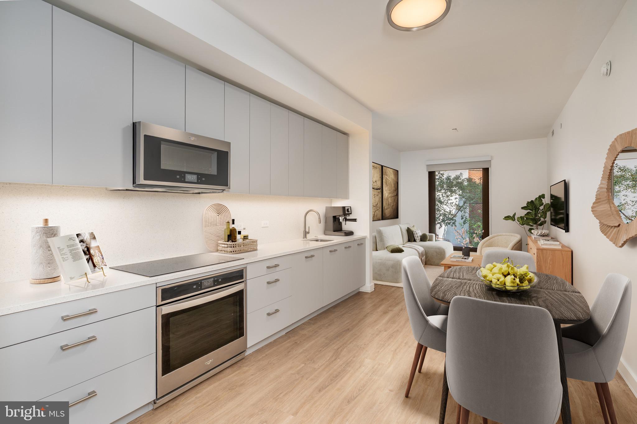 a kitchen with stainless steel appliances a stove a sink cabinets and a dining table