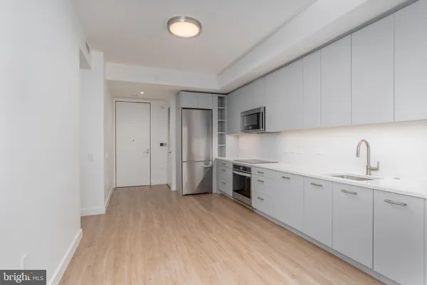 a kitchen with granite countertop white cabinets and stainless steel appliances