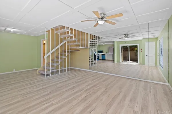 a view of a livingroom with a ceiling fan and hardwood floor