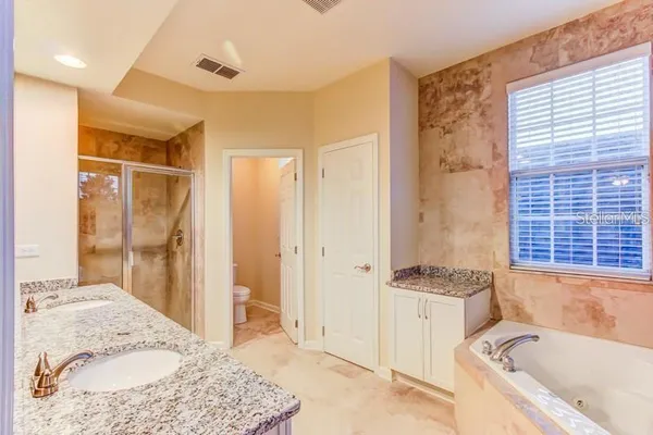 a bathroom with a tub a sink and a window