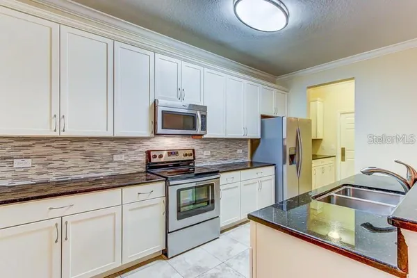 a kitchen with stainless steel appliances granite countertop a sink stove and refrigerator