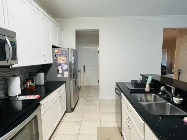 a kitchen with granite countertop a sink and cabinets