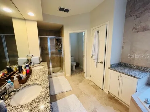 a bathroom with a granite countertop sink a mirror and a shower