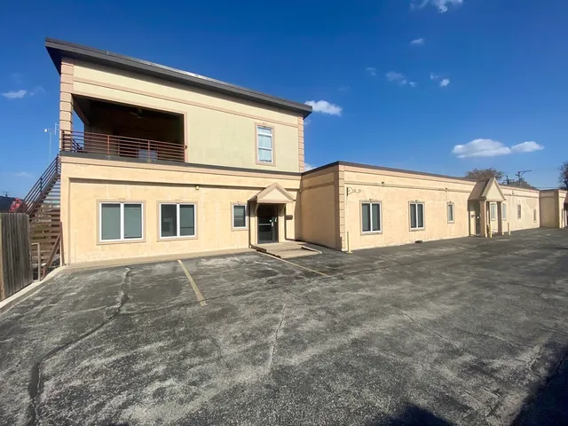 a view of a white house with a yard