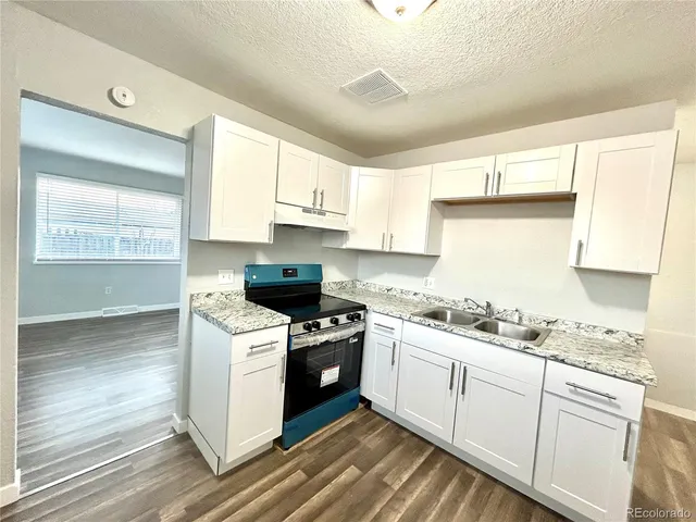 a kitchen with a stove a sink and a window