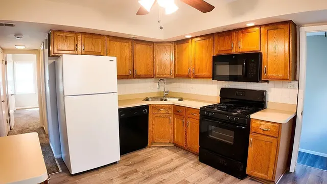 a kitchen with granite countertop a refrigerator stove top oven and sink
