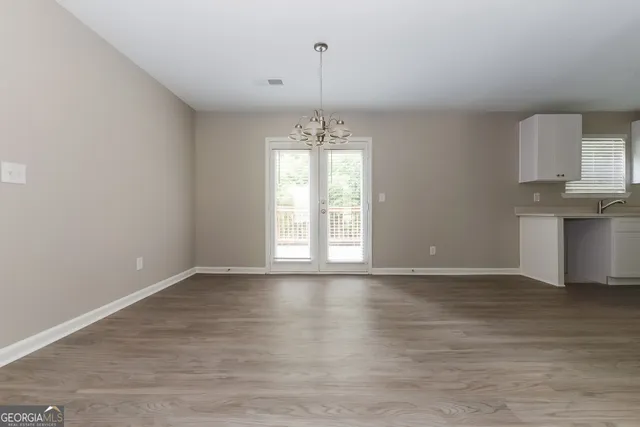 a view of a room with wooden floor staircase and a kitchen