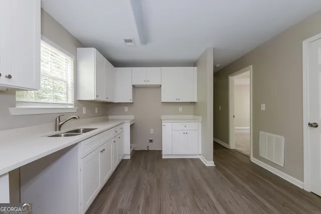 a kitchen with a sink stove and cabinets