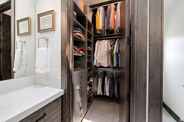 11547 Soaring Hawk Lane Hideout, UT 84036 - Photo 28 of 43 Custom closet system featuring dark wood-finish cabinetry, integrated shelving, and multiple hanging rods