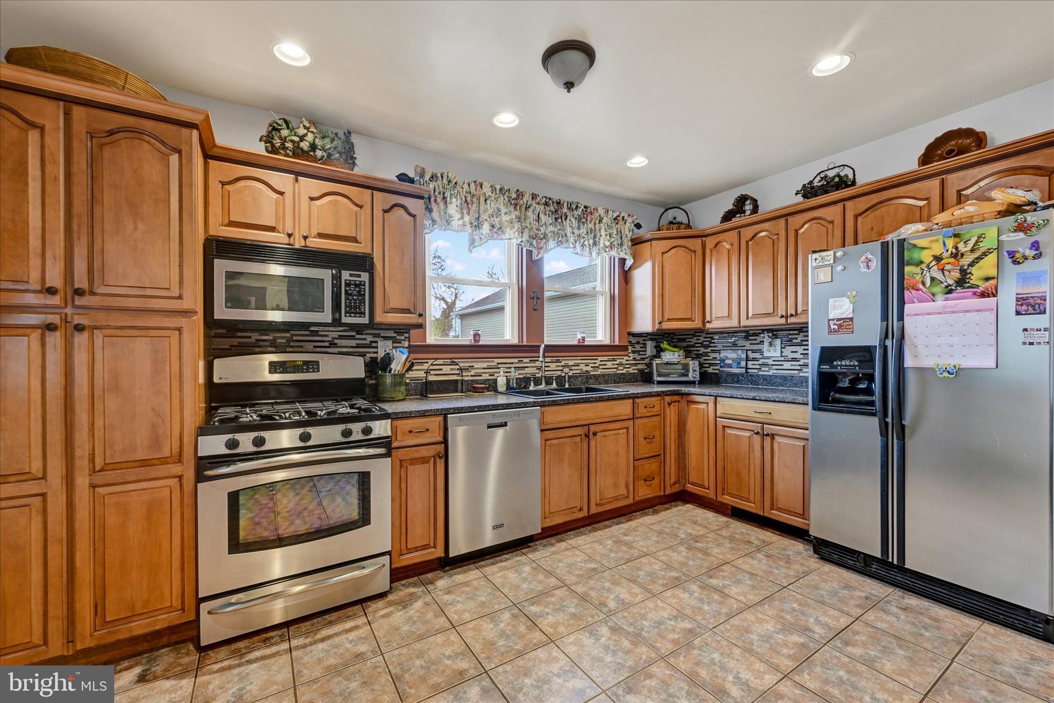 4630 Magnolia Avenue Baltimore, MD 21227 - Photo 11 of 31 a kitchen with granite countertop a refrigerator and a stove top oven