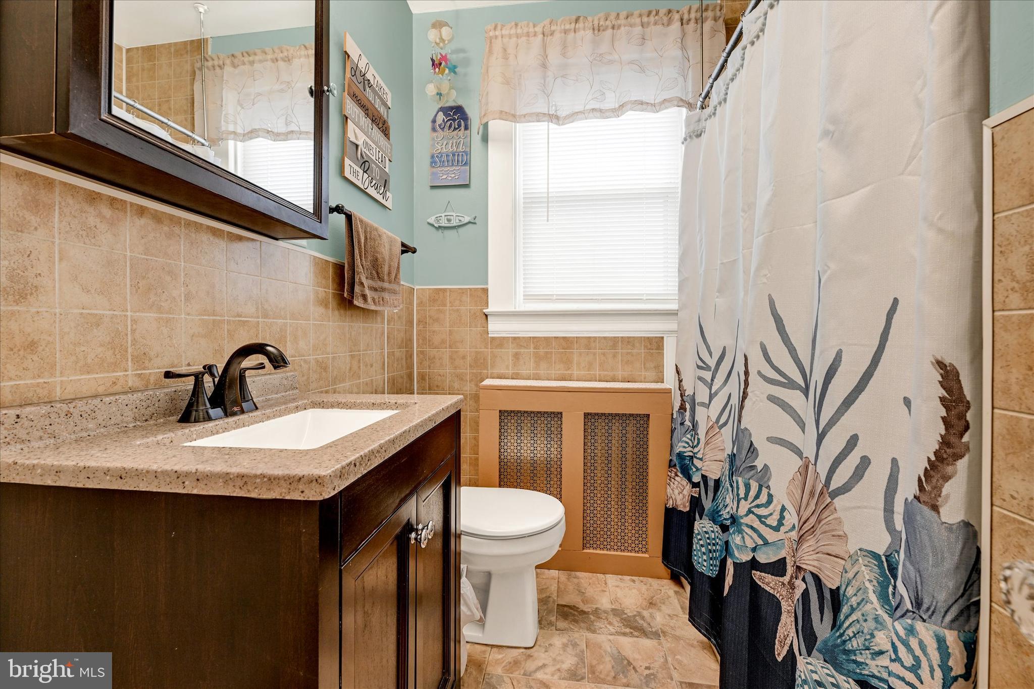 4630 Magnolia Avenue Baltimore, MD 21227 - Photo 13 of 31 a bathroom with a granite countertop sink and a toilet