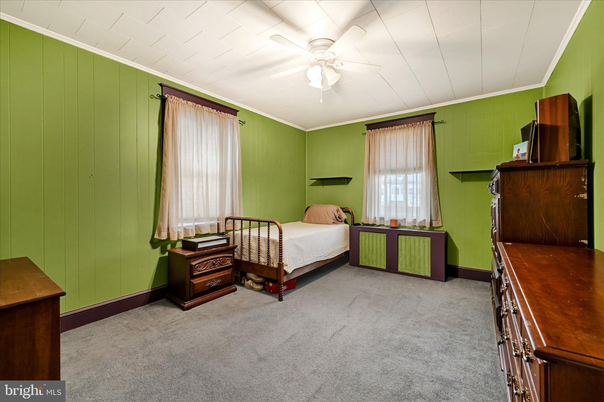 4630 Magnolia Avenue Baltimore, MD 21227 - Photo 14 of 31 a bedroom with a bed and a dresser next to a window