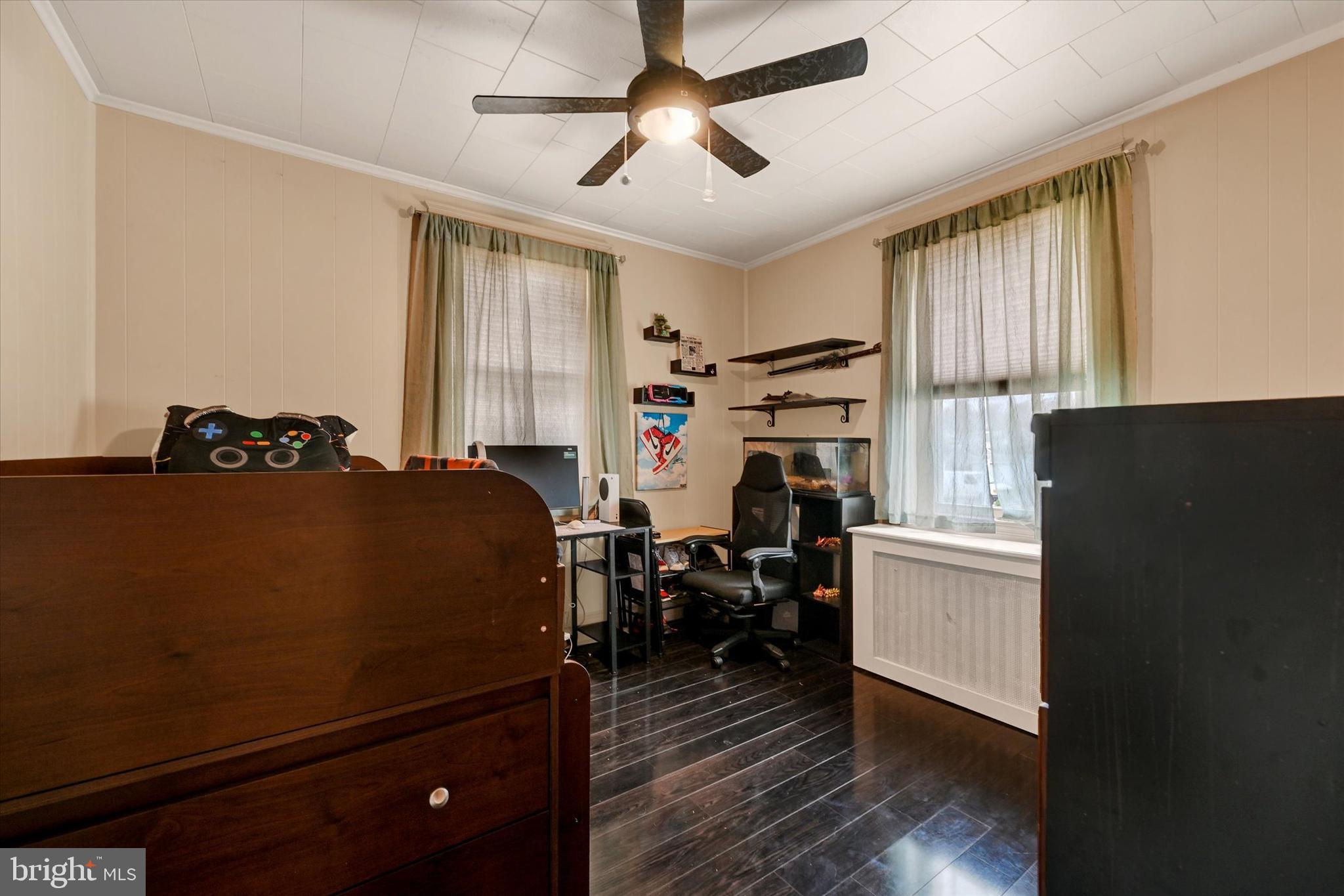 4630 Magnolia Avenue Baltimore, MD 21227 - Photo 16 of 31 a bedroom with a bed and wooden floor